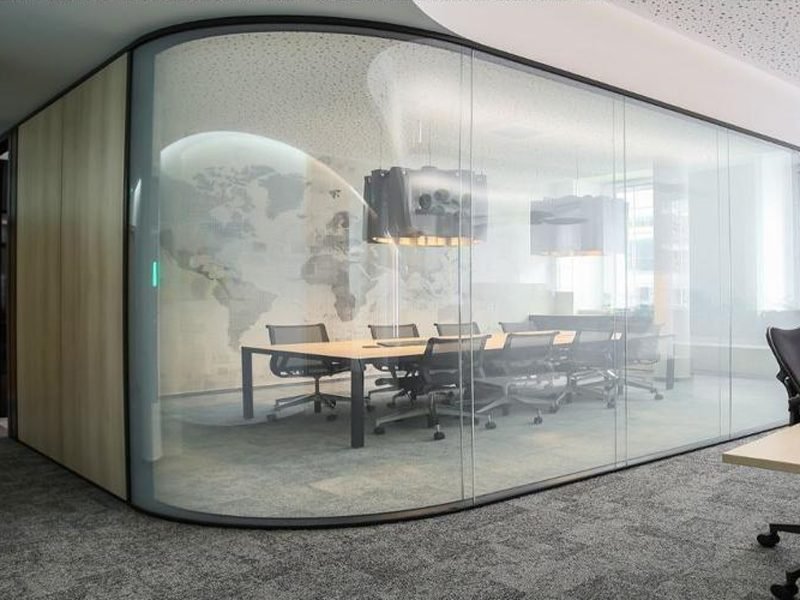 Curved glass meeting room wall, clear, with the conference table visible